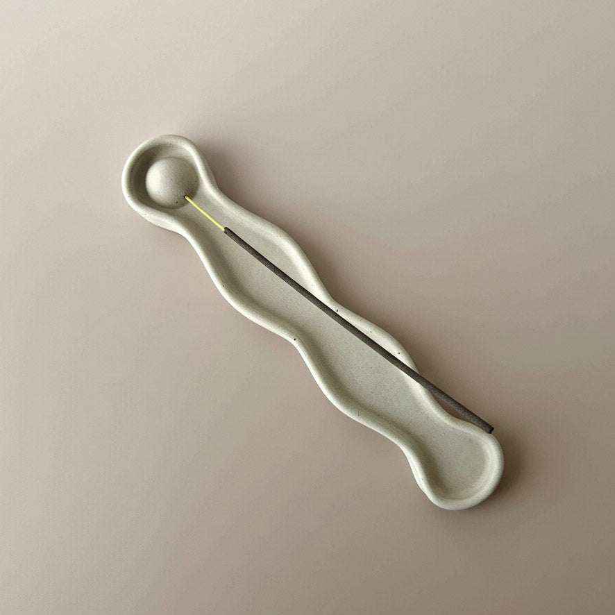 Rankų darbo minimalistinė betono smilkalinė „Mindfulness“ su unikaliu dizainu ir ramybės simboliu.