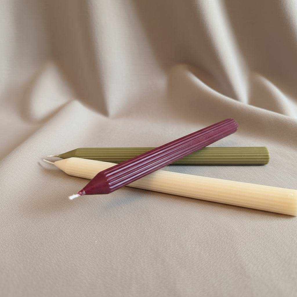 Rapsų vaško žvakės "Vytė" su stambiais vertikaliais ruožais įvairių spalvų ant šviesaus fono