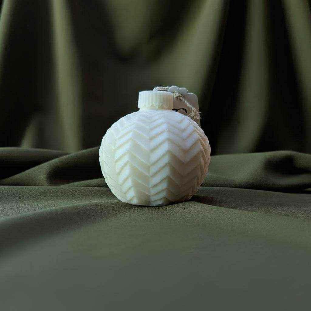 Balta rankų darbo rapsų vaško žvakė su ornamentu, primenančiu Kalėdų eglutės žaisliuką