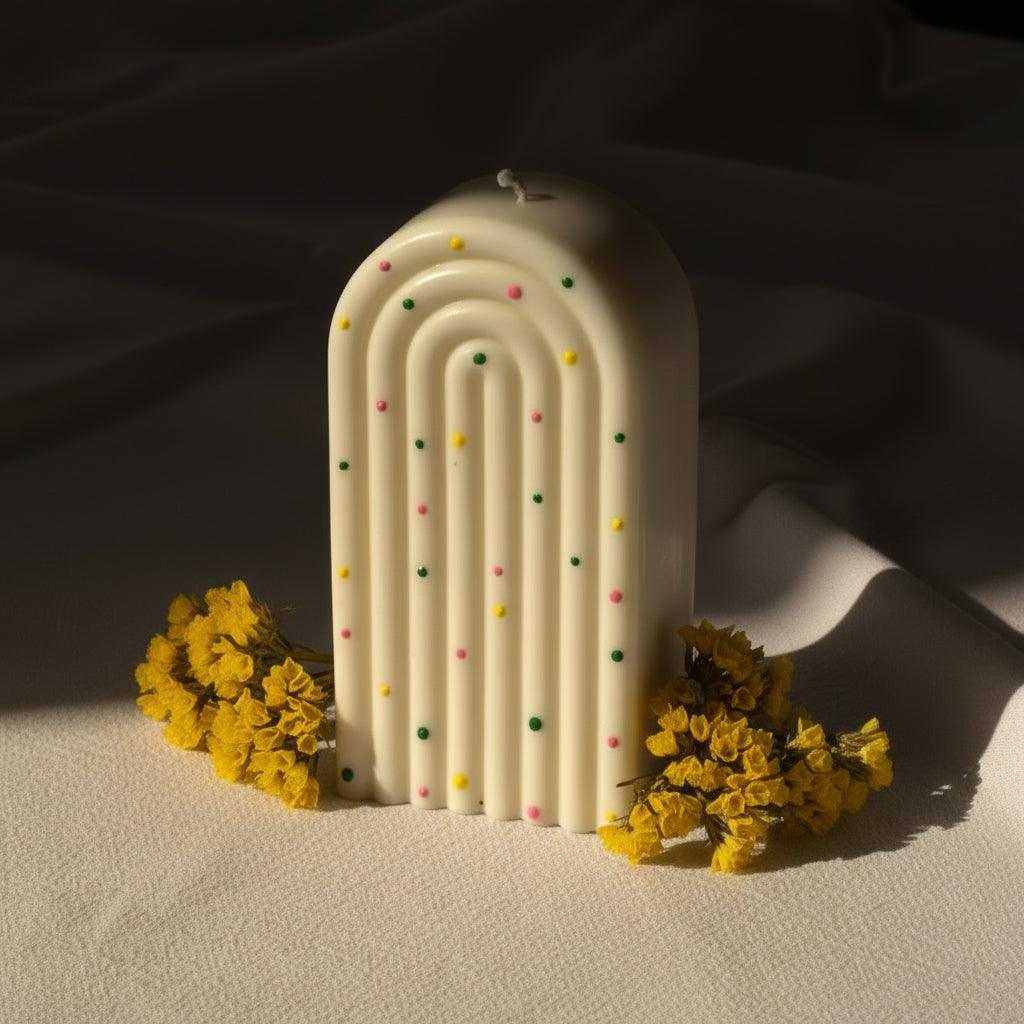 Dekoruota sojų vaško žvakė su spalvotais tašeliais ir arkos formos dizainu