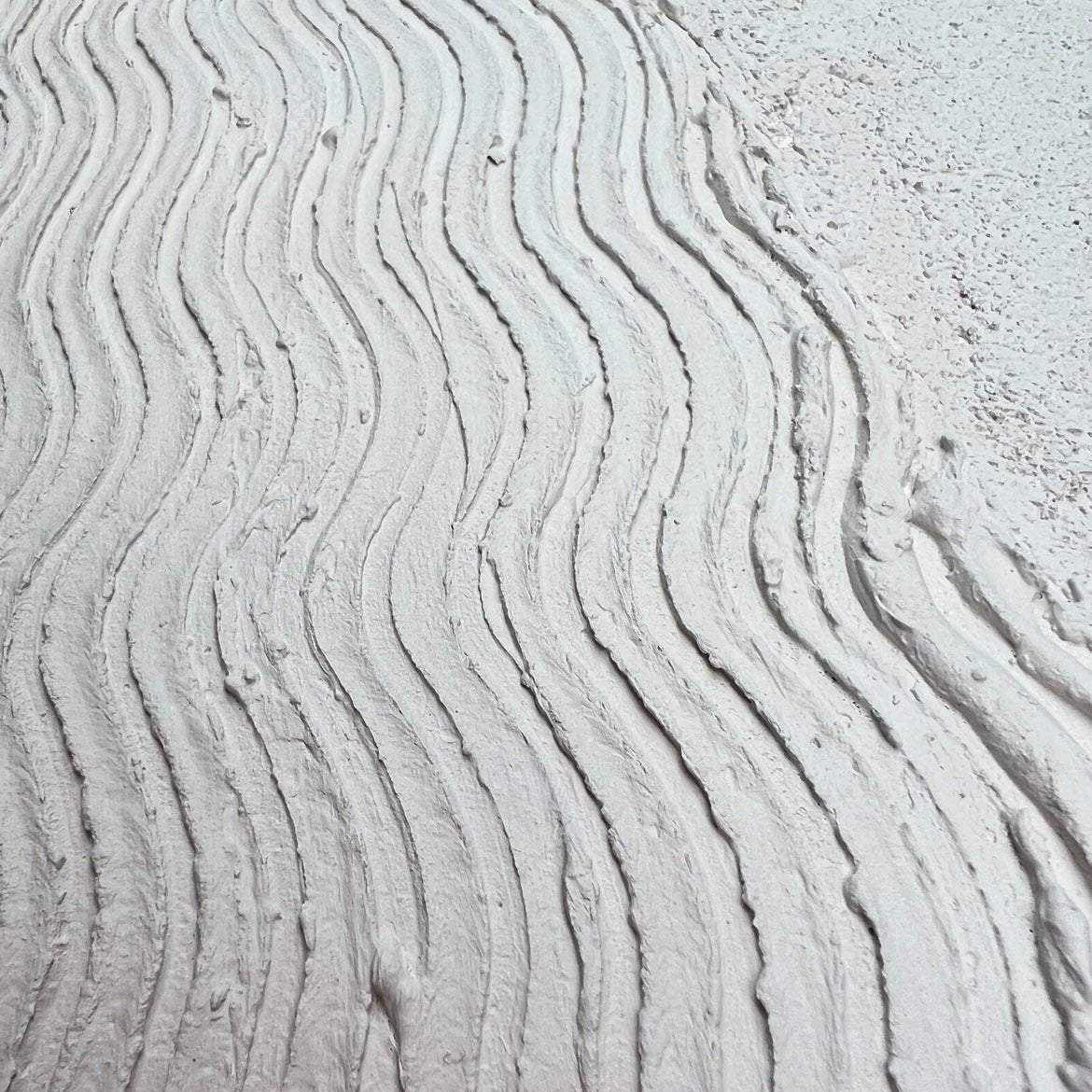 Tekstūrinis paveikslas Prolatio su banguotomis smėlio linijomis ir pirštų prisilietimu