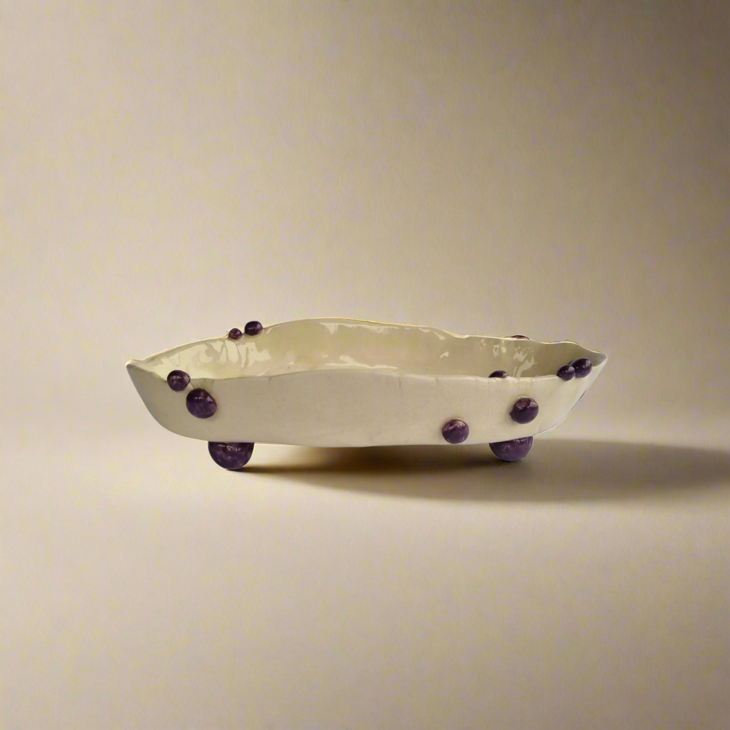 Balto molio vazelė „Išdygo spuogas“ su tamsiai slyviniais burbuliukais boho stiliaus interjere