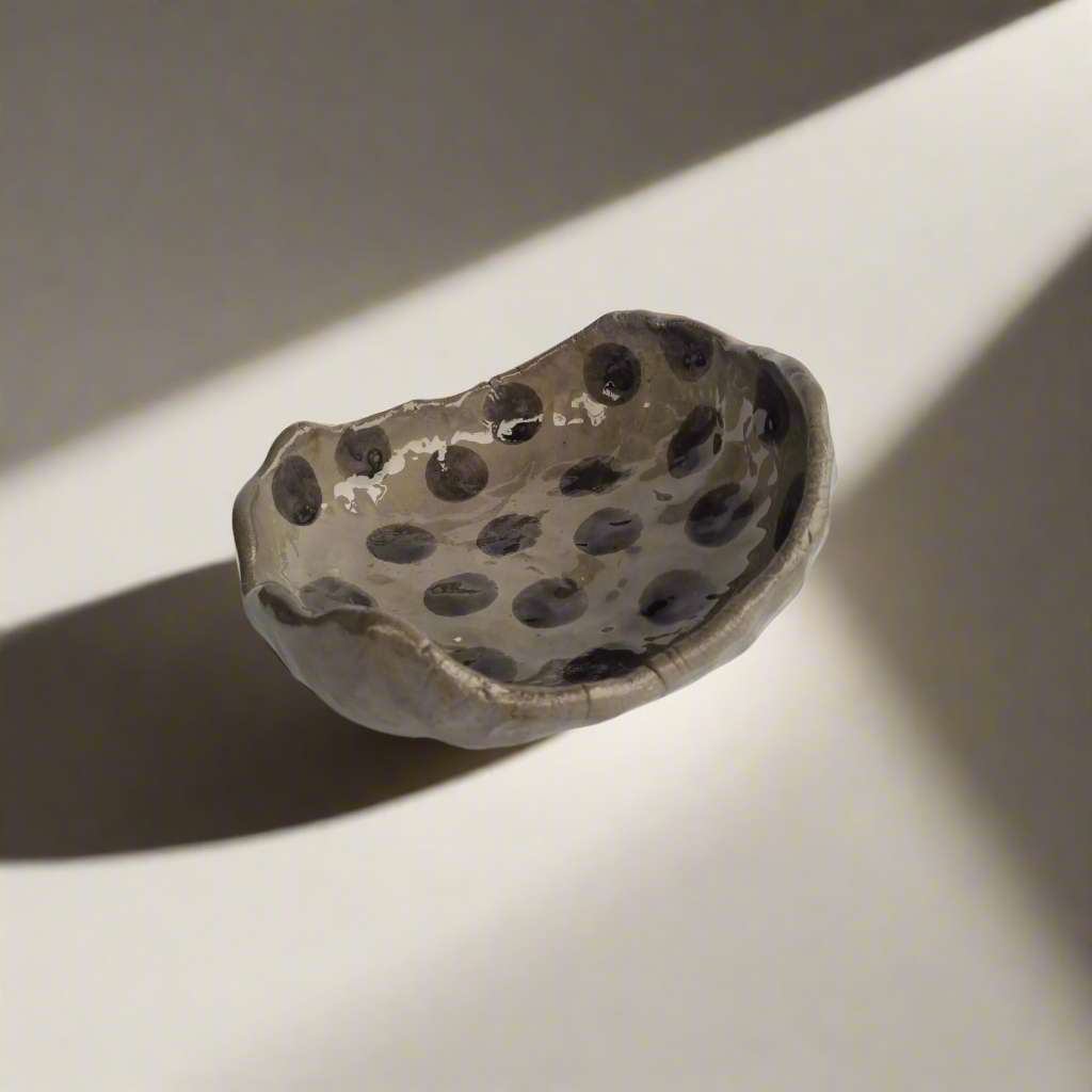 Pilko molio nelygios formos taškuota saldaininė su tamsiais burbuliukais moderniam interjerui